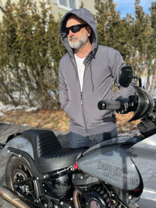 Rider-Stands-Next-To-Motorcycle-Wearing-Sunglasses-And-Gray-Matte-Protective-Hoodie