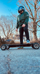 rider-stands-on-skateboard-in-green-protective-hoodie