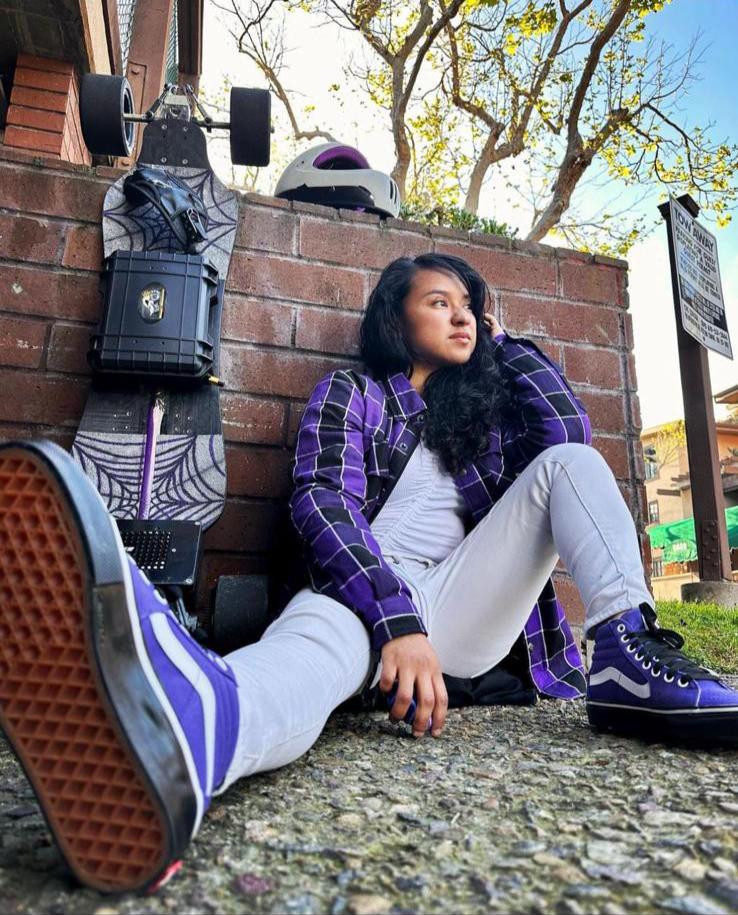 Woman-Sits-on-Ground-Wearing_Flannel-Shirt-in-Purple-Black-and-White-Stripe